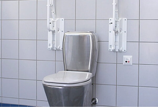 Kompakt-WC-V130-S-trap,-dostosowany-do-osob-niepelnosprawnych,-wykonany-ze-stali-nierdzewnej,-w-toalecie-na-tle-bialych-kafelkow Kompakt-WC-V130-S-trap,-dostosowany-do-osob-niepelnosprawnych,-wykonany-ze-stali-nierdzewnej,-w-toalecie-na-tle-bialych-kafelkow